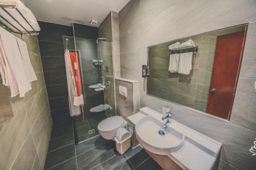 y baño con lavabo, aseo y ducha. en Hotel Kaonia, en Sarandë