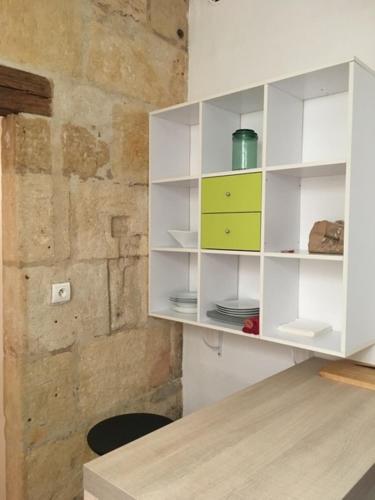 une armoire blanche dans une pièce avec une table dans l'établissement Appart sympa Nimes centre, à Nîmes