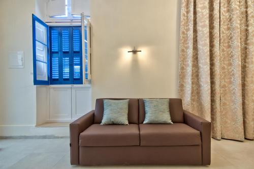 a white couch sitting in front of a window at The Suites – Piazza Kirkop in Kirkop
