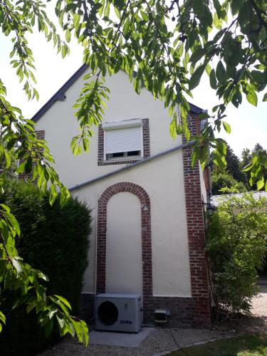 a small white house with a window and an arch at la ville à la campagne in Lisieux