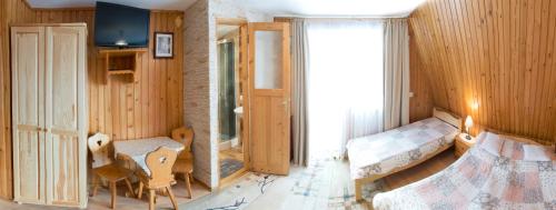 a bedroom with wooden walls and a bed and a window at Willa Irys in Bukowina Tatrzańska