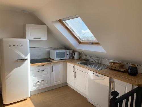 une cuisine avec un réfrigérateur blanc et une fenêtre dans l'établissement Le Wim'Heureux Mer. Villa Sainte thérèse, à Wimereux