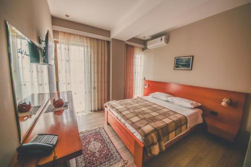 a hotel room with a bed and a desk at Hotel Kaonia in Sarandë