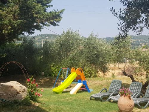 a playground with a slide and chairs in a yard at Il Casale della Quercia in Assisi