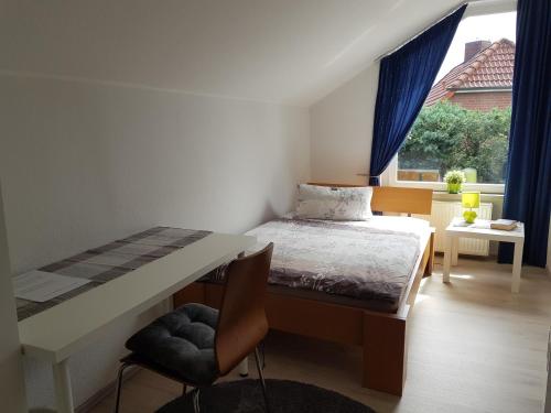 a bedroom with a bed and a desk and a window at Gästehaus Keßling in Trittau