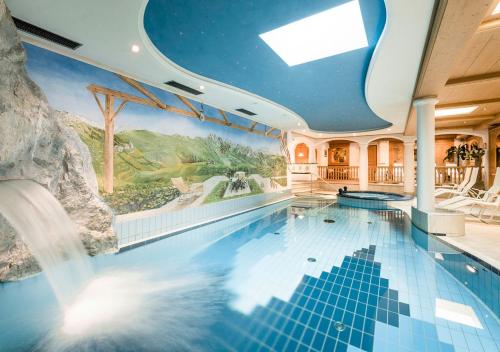 a swimming pool with a painting on the wall at Wellness Residence Villa Leck in Selva di Val Gardena