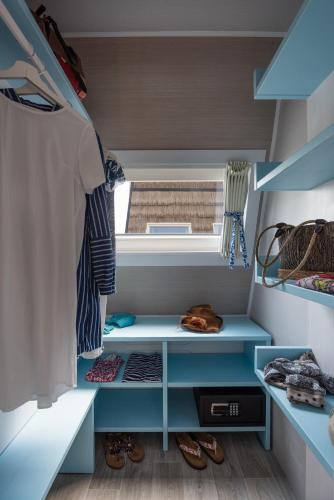 a walk in closet with blue shelves and a window at Marina Azzurra Resort in Lignano Sabbiadoro