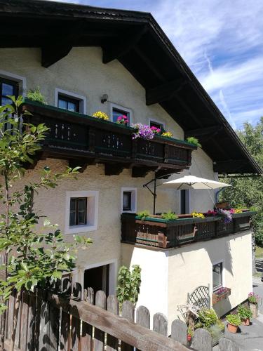 a building with a balcony with flowers on it at Gasthof Oberwirt in Lend