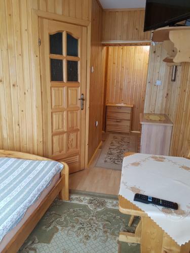 a small room with a bed and a door at Willa Irys in Bukowina Tatrzańska