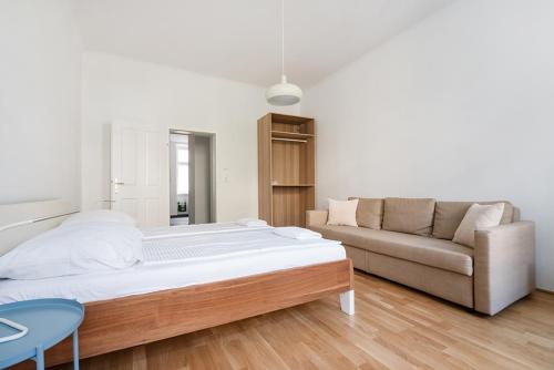 ein Wohnzimmer mit einem Bett und einem Sofa in der Unterkunft UNIVERSUM APARTMENT in Wien