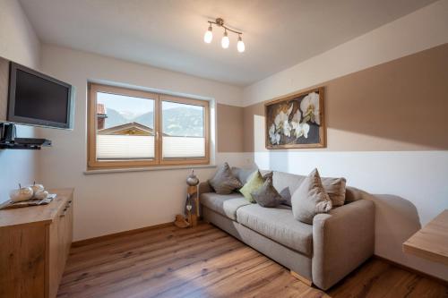 a living room with a couch and a window at Apart Bergluft in Gerlosberg