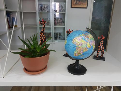a globe on a desk next to a plant at Tara Lodge in Ulaanbaatar