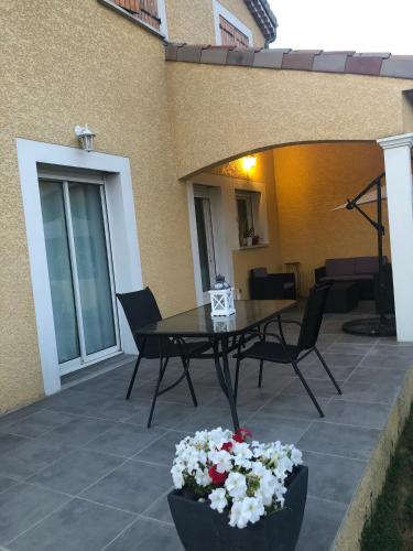 - une terrasse avec une table, des chaises et des fleurs dans l'établissement Villa 605 - climatisé, à Tain-lʼHermitage