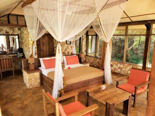 a bedroom with two beds and a table and chairs at Seasons Lodge Zanzibar in Pongwe