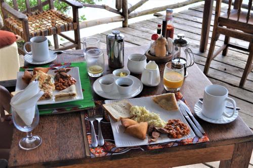 a wooden table with plates of food on it at Seasons Lodge Zanzibar in Pongwe