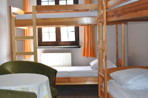 a bunk bed room with two bunk beds and a table at Hostel Przy Targu Rybnym in Gdańsk