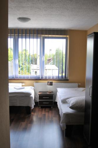 due letti in una stanza con due finestre di Villavida a Poznań