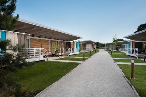 a walkway in front of a row of houses at Lino delle Fate Eco Resort in Bibione