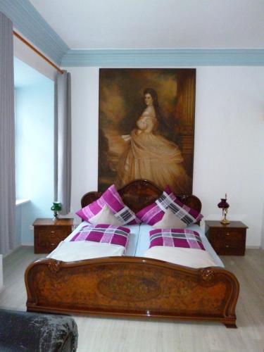 a bedroom with a bed with a painting on the wall at Lucky Home Sissi Appartment in Füssen