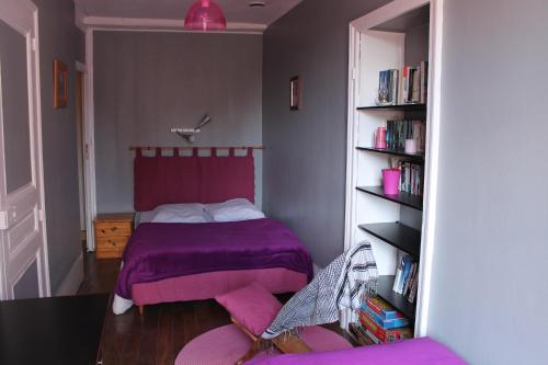 - une chambre avec un lit violet et une étagère à livres dans l'établissement Maison Familiale À Recey-Sur Ource, à Recey-sur-Ource