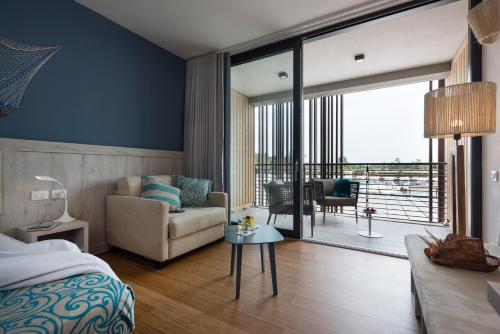 a bedroom with a bed and a living room with a view at Lino delle Fate Eco Resort in Bibione