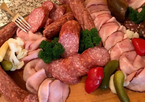 a tray of meat and sausage and vegetables on a table at Ringhotel Roggenland in Waldeck
