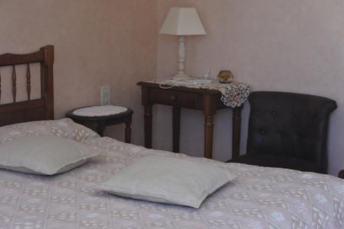 a bedroom with a bed with a table and a chair at Gîtes du Ménez-Hom in Plomodiern