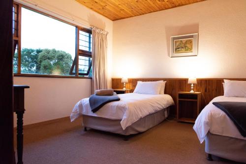 a bedroom with two beds and a large window at Natures Way Farmhouse in The Crags