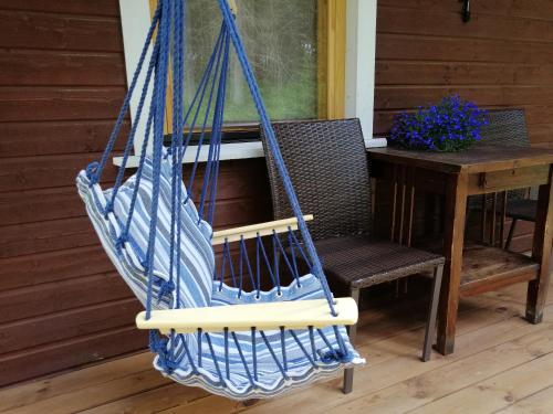 a blue hammock hanging on a porch next to a table at Ainja Puhkemaja in Viljandi