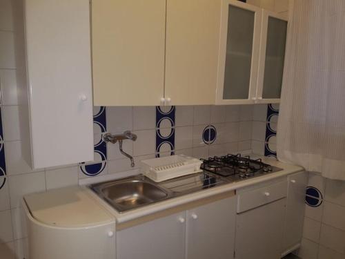 uma cozinha com um lavatório e um fogão em Villa Giada-8 appartamenti em Leporano