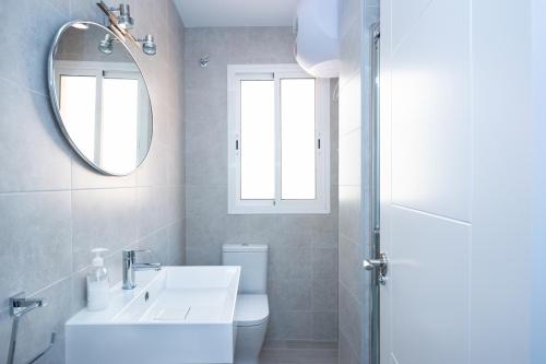 een witte badkamer met een wastafel en een spiegel bij Marmoles Sweet Home in Málaga