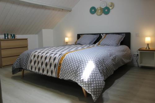 a bedroom with a bed with a black and white comforter at Bel appartement avec vue sur vézère in Uzerche