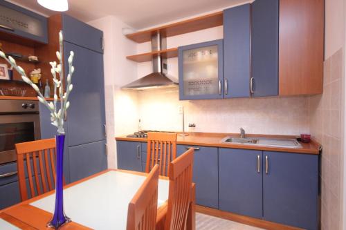 een keuken met blauwe kasten, een tafel en een wastafel bij Apartment Karlo near the most beautiful beach Žnjan in Split