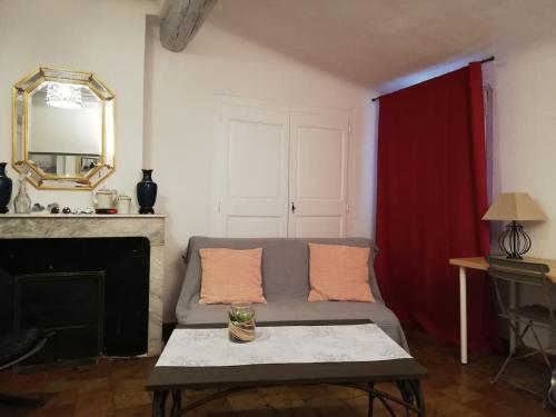 a living room with a couch and a mirror at Studio ensoleillé, typique centre historique, wifi in Aix-en-Provence