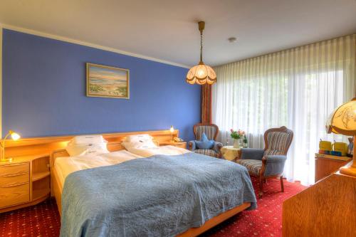 Un dormitorio con una cama y una pared azul. en Hotel Katharina Garni, en Tübingen