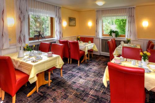 Un comedor con mesas y sillas rojas. en Hotel Katharina Garni, en Tübingen