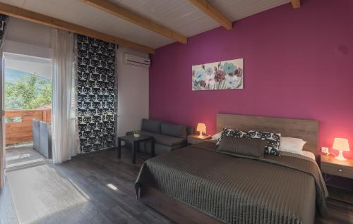 a bedroom with a bed and a purple wall at Villa Rubčić Rooms in Rakovica