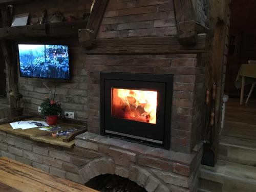 a brick fireplace with a tv on top of it at Matanovi Dvori in Slavonski Brod