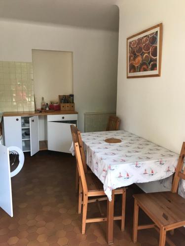 une cuisine avec une table et des chaises dans une pièce dans l'établissement Au calme près de la forêt à 2 kms des plages, à Capbreton