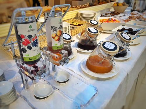 a table topped with jars and plates of food at Hotel Des Bains Terme in Montegrotto Terme