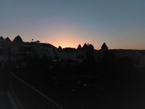 a view of the sun setting behind the mountains at Homestay Cave Hostel in Goreme