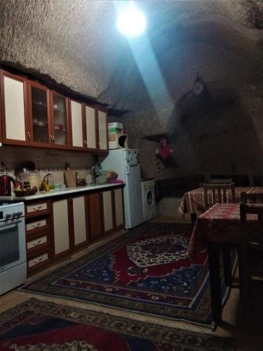 a kitchen with a table and a white refrigerator at Homestay Cave Hostel in Goreme