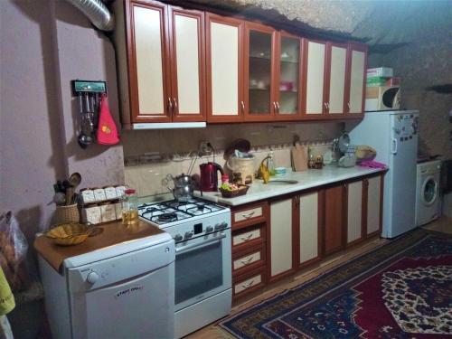a kitchen with a stove a sink and a microwave at Homestay Cave Hostel in Goreme