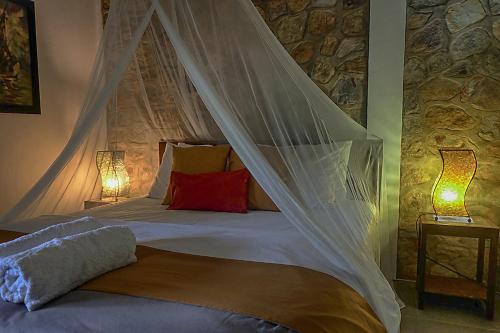 - une chambre avec un lit et une moustiquaire dans l'établissement Ayu Hotel Karimunjawa, à Karimunjawa