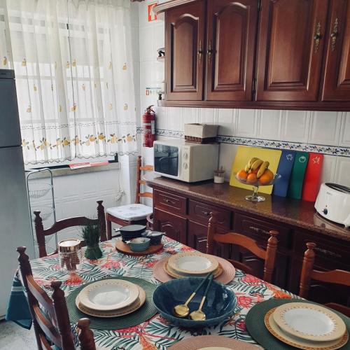 a kitchen with a table with chairs and a microwave at Two bedroom apartment, two minutes from the beach in Nazaré