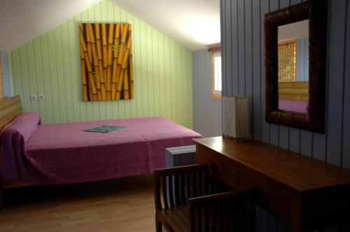 a bedroom with a purple bed and a mirror at GREEN HOUSE in Deshaies