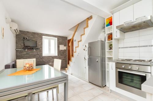La cuisine est équipée d'un comptoir et d'un réfrigérateur. dans l'établissement Apartments Bepina, à Split
