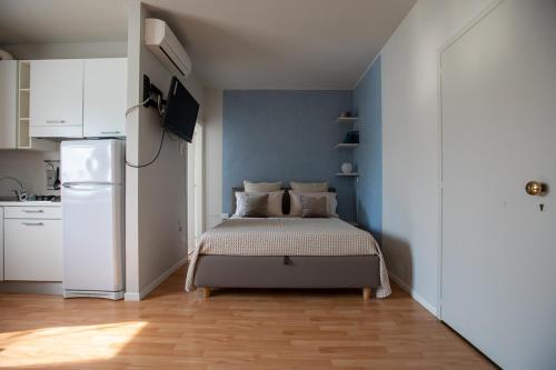a small bedroom with a bed and a refrigerator at LULLABY HOUSE LAZISE in Lazise