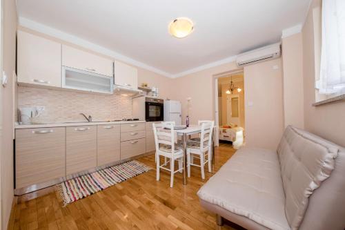a kitchen with a couch and a table and chairs at Apartmani Rab in Kampor