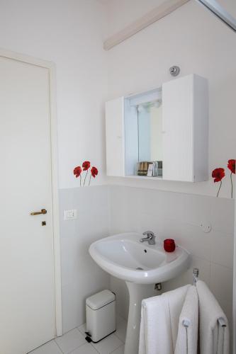 a white bathroom with a sink and a mirror at LULLABY HOUSE LAZISE in Lazise